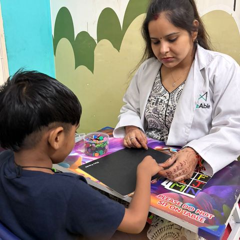 A child playing a board game with a therapist.
