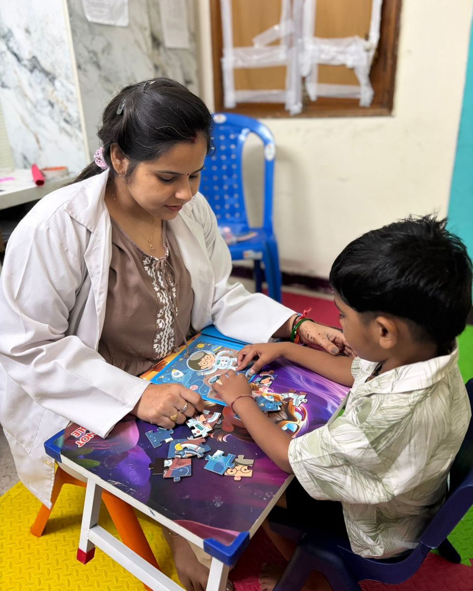 A therapist and a child putting a jigsaw puzzle together.