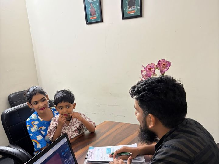Two children sitting together at a desk with a CureAble team member.