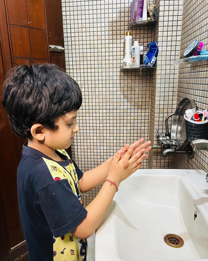 A child washing his hands at a bathroom basin at home.