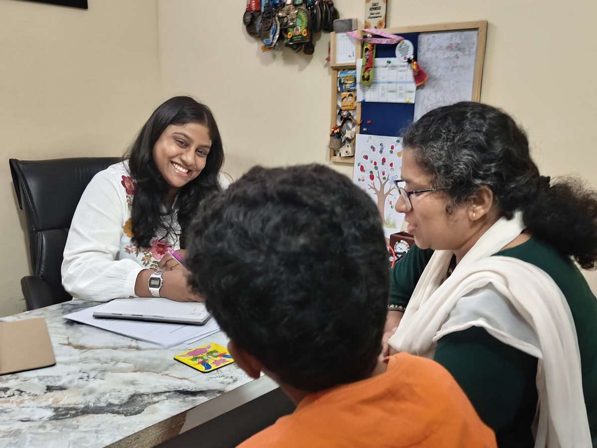 A CureAble clinician meets a parent and child for a counselling session at a CureAble centre.