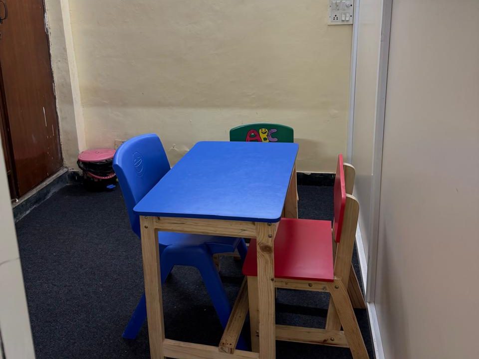 A small therapy cabin at the Noida Centre, with a blue table and red and blue child-size chairs.